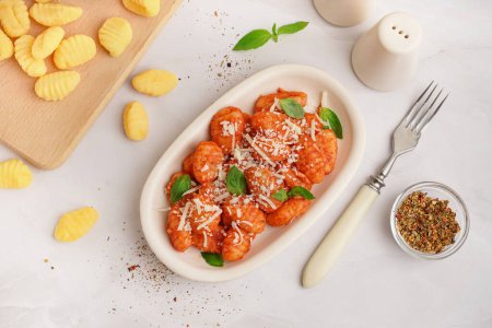 Assiette de gnocchis savoureux avec sauce tomate et fromage sur fond blanc