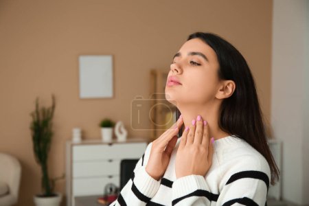Photo for Young woman suffering from thyroid gland problem at home - Royalty Free Image