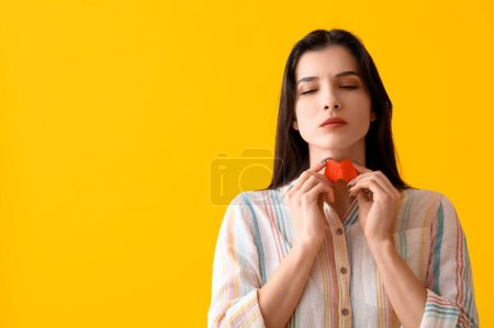 Photo for Young woman with paper thyroid gland on yellow background - Royalty Free Image