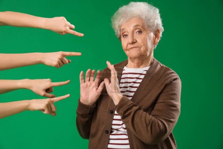Téléchargez les photos : Des gens pointant vers une femme âgée sur fond vert. Concept d'accusation - en image libre de droit