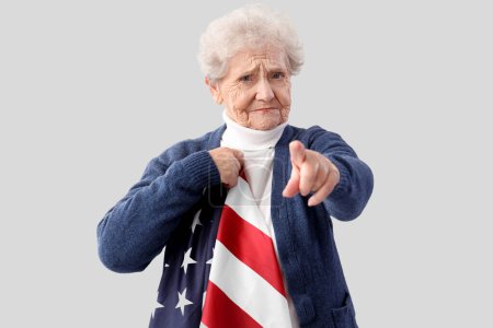 Eine ältere Frau mit USA-Flagge zeigt auf den Betrachter auf hellem Hintergrund. Amtsenthebungsverfahren
