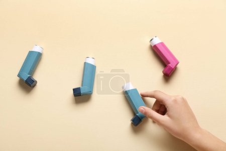 Téléchargez les photos : Main d'enfant avec inhalateurs d'asthme sur fond beige - en image libre de droit