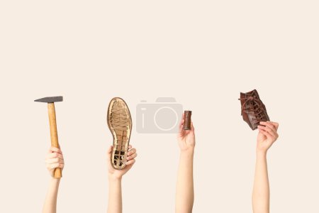 Photo for Female hands with shoe pieces, hammer and sewing thread on white background. Shoes repair concept - Royalty Free Image