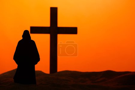 Photo for Jesus with wooden cross on sand against orange background. Good Friday concept - Royalty Free Image