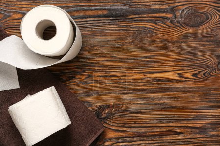 Téléchargez les photos : Rouleaux de papier toilette et serviette sur fond en bois - en image libre de droit