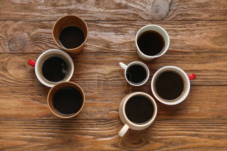 Foto de Muchas tazas de café caliente sobre fondo de madera - Imagen libre de derechos