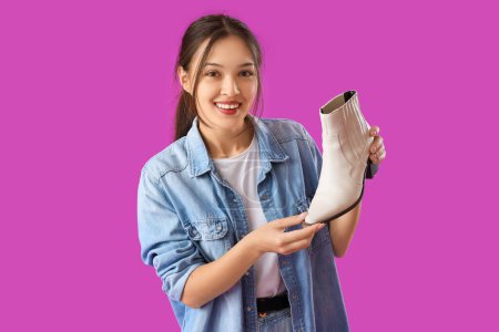 Photo for Young Asian seller with boot on purple background - Royalty Free Image