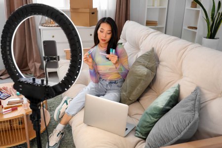 Foto de Mujer asiática belleza blogger con brillo de labios grabación de vídeo en casa - Imagen libre de derechos