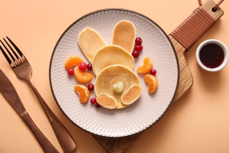 Téléchargez les photos : Crêpes de lapin de Pâques drôles avec mandarine et baies sur fond orange - en image libre de droit