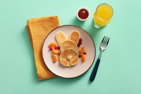 Téléchargez les photos : Crêpes de lapin de Pâques drôles avec mandarine et baies sur fond turquoise - en image libre de droit