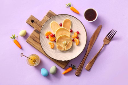 Téléchargez les photos : Crêpes de lapin de Pâques drôles avec mandarine et baies sur fond lilas - en image libre de droit