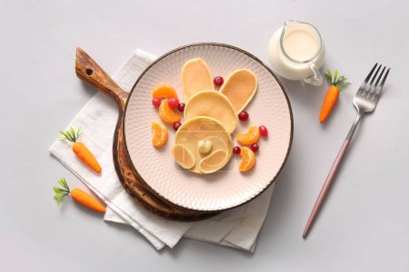 Téléchargez les photos : Crêpes de lapin de Pâques drôles avec mandarine et baies sur fond gris - en image libre de droit