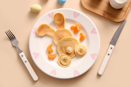 Téléchargez les photos : Crêpes de lapin de Pâques drôles avec mandarine et banane sur fond jaune - en image libre de droit