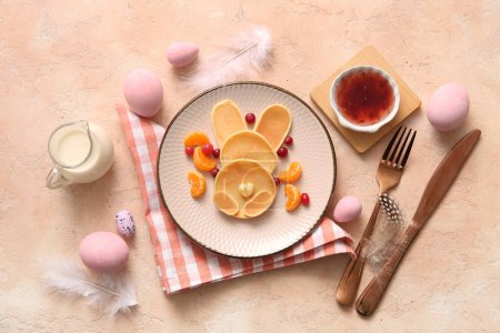 Téléchargez les photos : Crêpes de lapin de Pâques drôles avec des œufs peints sur fond beige - en image libre de droit