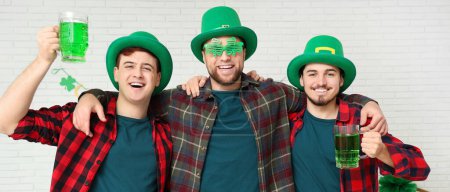 Photo for Happy young men with mugs of green beer on light background. St. Patrick's Day celebration - Royalty Free Image