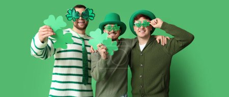 Photo for Happy young men with clovers on green background. St. Patrick's Day celebration - Royalty Free Image