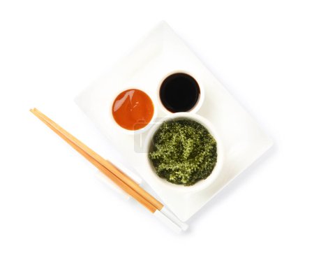Foto de Placa con algas sanas, salsas y palillos sobre fondo blanco - Imagen libre de derechos