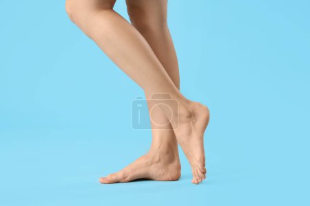 Téléchargez les photos : Femme pieds nus marchant sur fond bleu - en image libre de droit