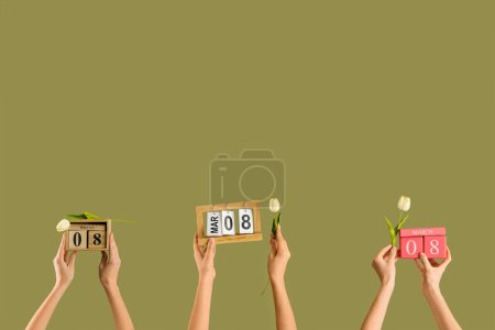 Photo for Female hands with calendars and tulips on green background. International Women's Day celebration - Royalty Free Image