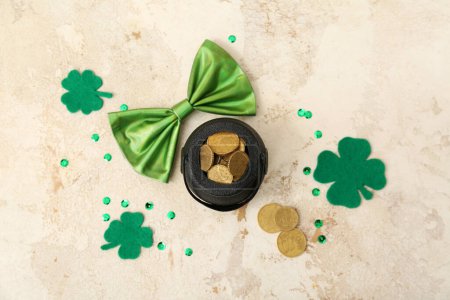 Photo for Leprechaun pot with golden coins and clover leaves on beige grunge background. St. Patrick's Day celebration - Royalty Free Image