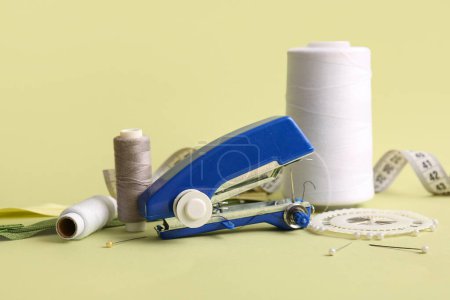 Foto de Máquina de coser manual con diferentes suministros sobre fondo verde - Imagen libre de derechos