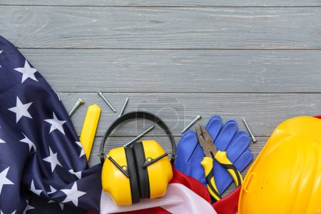 Foto de Alicates, equipo de protección y bandera de EE.UU. sobre fondo de madera gris. Fiesta del Día del Trabajo - Imagen libre de derechos