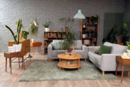 Foto de Vista borrosa del salón con plantas, sofás y mesas - Imagen libre de derechos