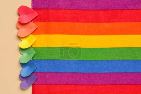 Composition avec drapeau arc-en-ciel et coeurs en papier coloré sur fond de couleur, gros plan. Fête de la Saint-Valentin