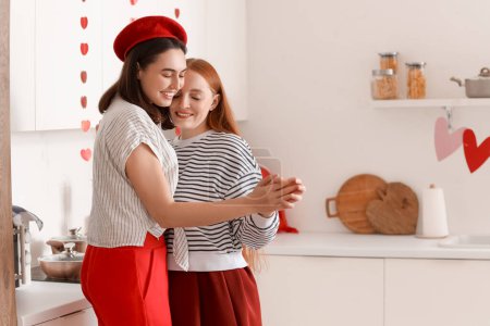 Jeune couple lesbien dansant dans la cuisine le jour de la Saint Valentin