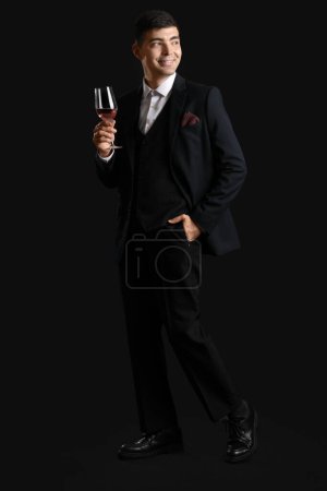 Photo for Young sommelier with glass of pink wine on black background - Royalty Free Image