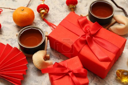 Photo for Gift boxes with cups of tea, fortune cookies and Chinese symbols on grunge background. New Year celebration - Royalty Free Image