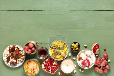 Traditionelle östliche Gerichte und türkischer Tee auf grünem Holztisch. Ramadan-Feier