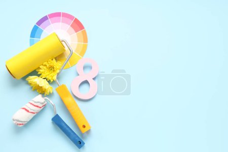 Foto de Composición con rodillos de pintura, muestras de paleta y flores sobre fondo de color. Día Internacional de la Mujer - Imagen libre de derechos
