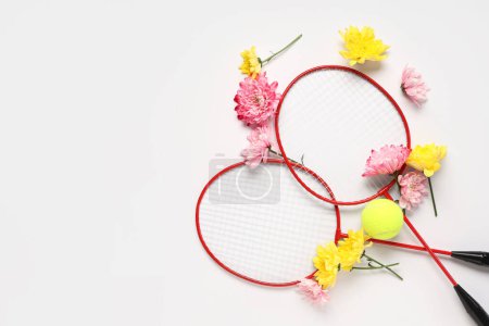 Photo for Composition with badminton rackets and flowers for International Women's Day on white background - Royalty Free Image
