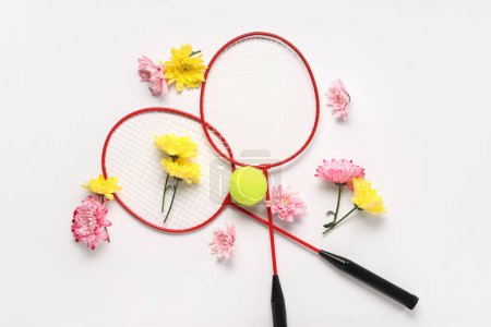 Téléchargez les photos : Composition avec raquettes de badminton, ballon et fleurs pour la Journée internationale de la femme sur fond blanc - en image libre de droit