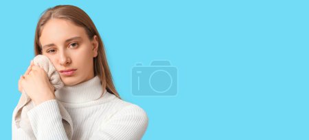 Junge Frau mit Zahnschmerzen auf hellblauem Hintergrund mit Platz für Text
