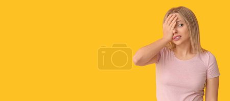 Photo for Young woman doing facepalm on yellow background with space for text - Royalty Free Image