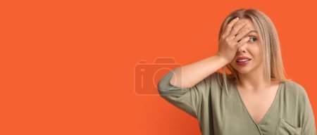 Young woman doing facepalm on orange background with space for text