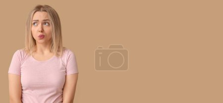 Photo for Embarrassed young woman on beige background with space for text - Royalty Free Image