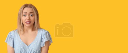 Embarrassed young woman on yellow background with space for text