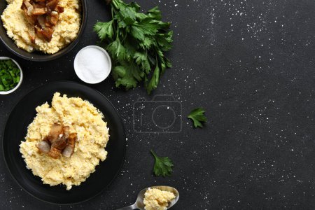 Téléchargez les photos : Assiette et bol de banosh savoureux sur fond noir - en image libre de droit