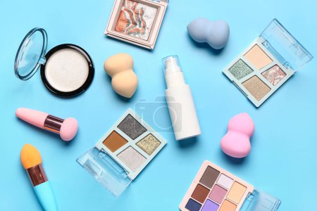 Téléchargez les photos : Différents produits cosmétiques décoratifs sur fond bleu - en image libre de droit