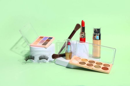 Téléchargez les photos : Différents cosmétiques de maquillage sur fond vert - en image libre de droit