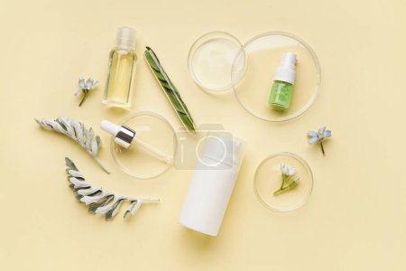 Photo for Petri dishes with bottles of cosmetic products and herbs on yellow background - Royalty Free Image