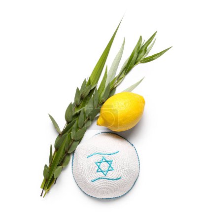 Vier Arten (lulav, hadas, arava, etrog) als Symbol des Sukkot-Festes und Kippa auf weißem Hintergrund