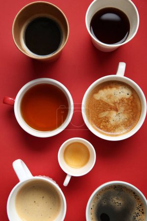 Foto de Muchas tazas de café caliente sobre fondo rojo - Imagen libre de derechos