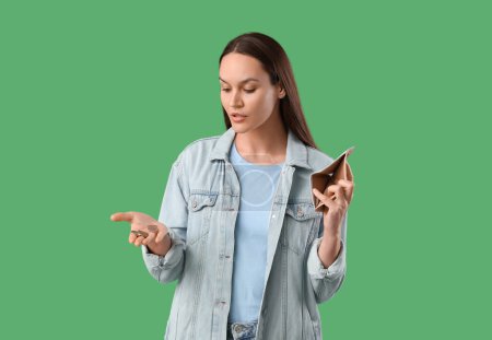 Photo for Young woman with coins and empty wallet on green background. Price rise concept - Royalty Free Image