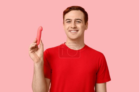 Beau jeune homme avec vibrateur sur fond rose