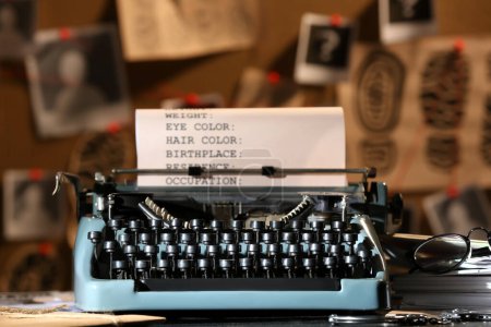 Retro-Schreibmaschine und Handschellen auf Tisch gegen Krimiwand
