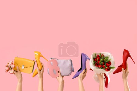 Téléchargez les photos : Mains féminines avec bouquet de tulipes, sacs à main et chaussures à talons hauts sur fond rose. Shopping pour la Journée internationale de la femme - en image libre de droit